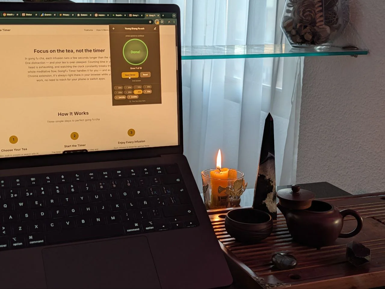 Cozy workspace with laptop showing GongFu Timer extension, traditional clay teapot on a tea tray with a candle — gong fu cha tea ceremony at a developer desk